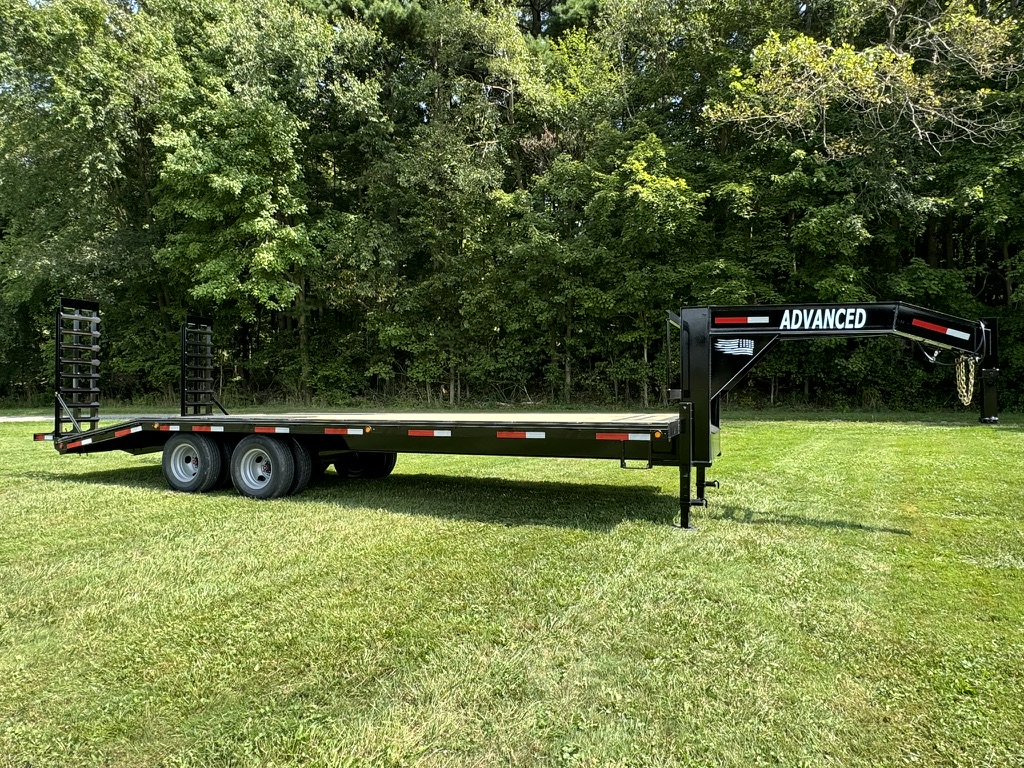 For sale in Ohio: a 20k Tandem Dual Gooseneck Trailer branded Advanced. This dual axle flatbed, surrounded by dense trees and resting on grass, features rear loading ramps.