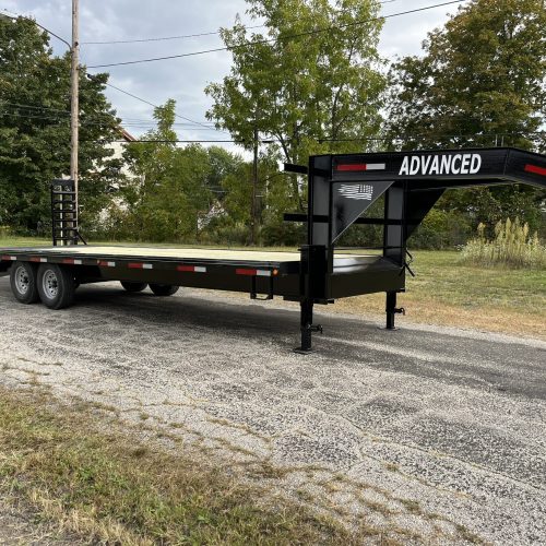 A black and red 16k Gooseneck Trailer is parked on a paved road in Ohio, showcasing ADVANCED on the gooseneck, dual axles, and metal ramps at the back. It’s set against trees and utility poles. Available for sale.