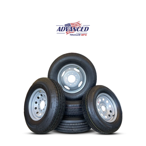 A stack of black Trailer Tires with silver rims is displayed, ideal for anyone seeking a trailer for sale. The top tire leans against the others, and above them, the ADVANCED TRAILER MFG logo appears with a small American flag design, proudly made in Ohio.